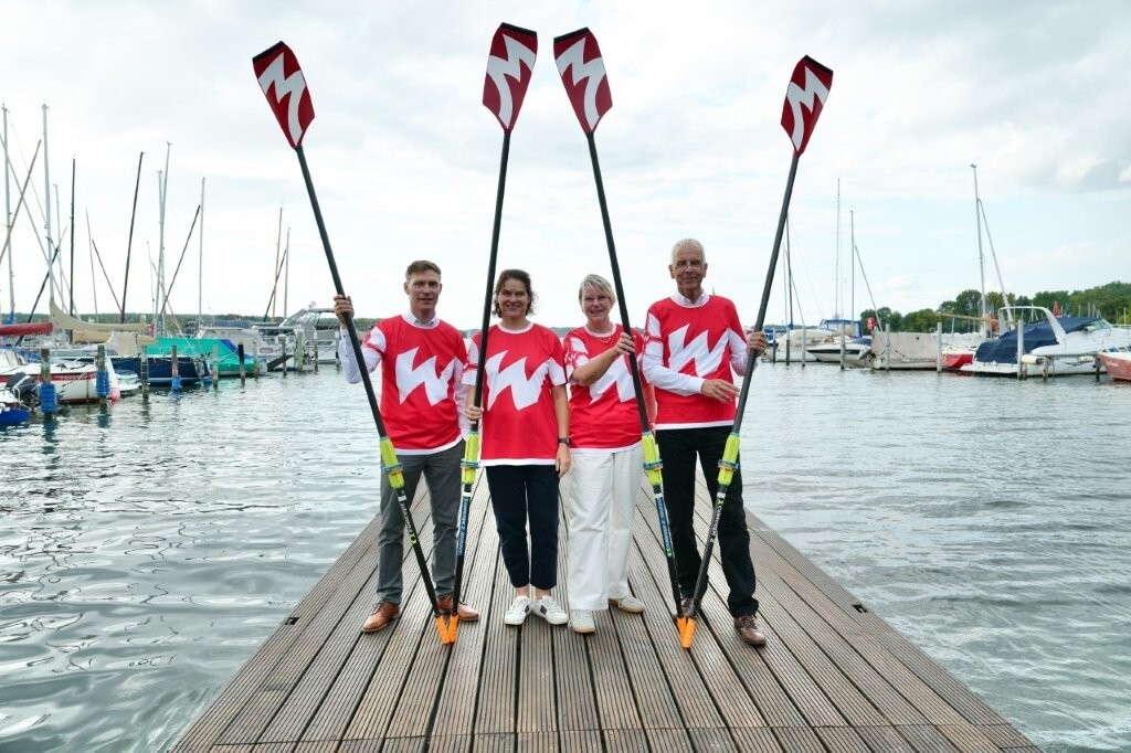 Der geschäftsführende Vorstand auf dem Steg mit T-Shirts und Bigblades, die ein W formen.